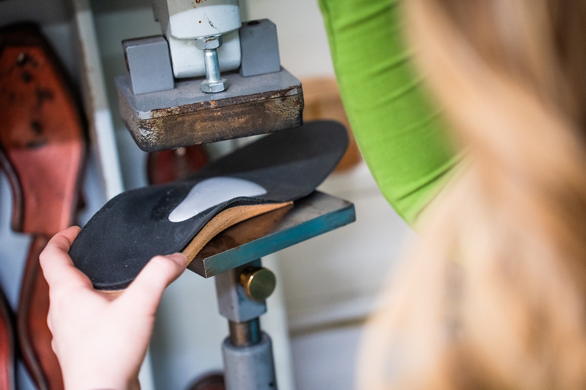 Orthopädische Einlegesohle wird mit einer Presse individuell angepasst.